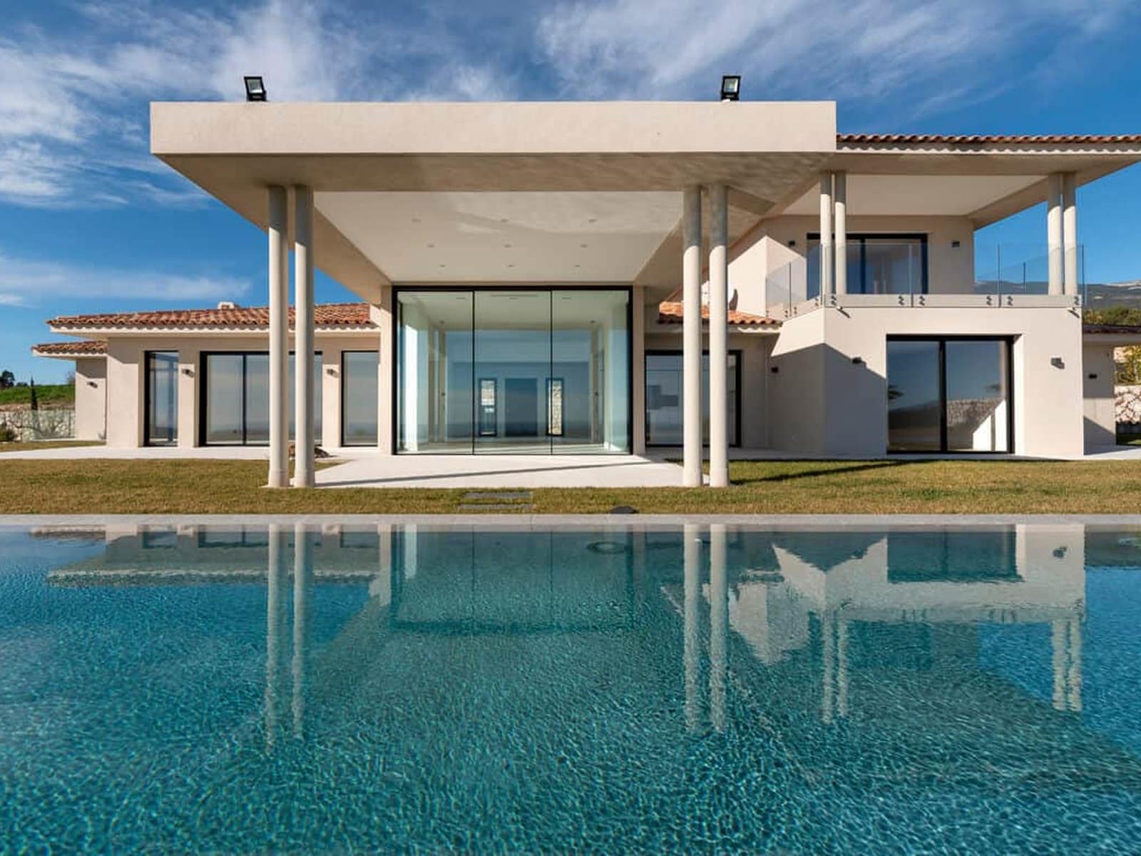 Sliding glass doors on a villa elevation above a pool terrace